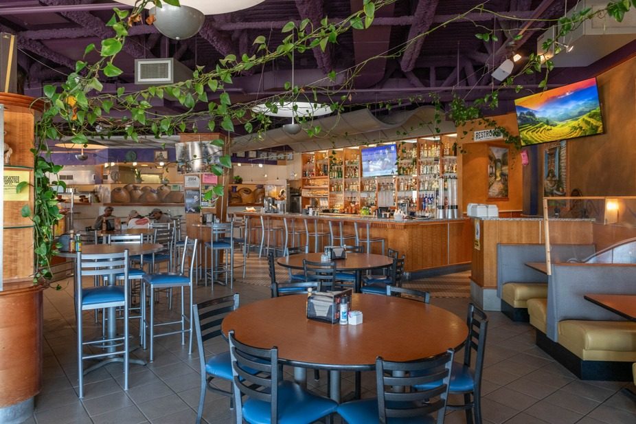 Dining room with hanging plants and booth seating at El Burrito Loco